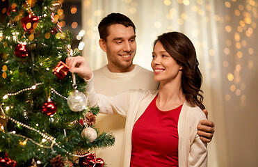 Image showing happy couple decorating christmas tree at home