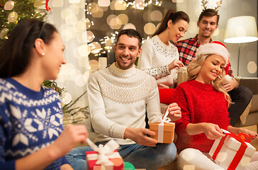 Image showing friends celebrating christmas and opening presents