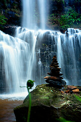 Image showing Zen waterfall with lush foliage and balancing stones