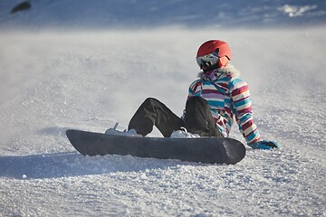 Image showing Snowboarder sitting in the snlow