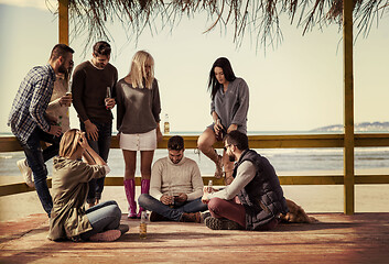 Image showing Group of friends having fun on autumn day at beach