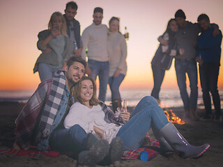 Image showing Couple enjoying with friends at sunset on the beach