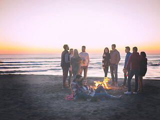 Image showing Couple enjoying with friends at sunset on the beach