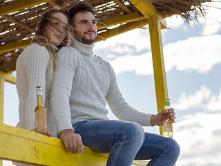 Image showing young couple drinking beer together at the beach