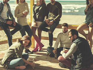 Image showing Group of friends having fun on autumn day at beach