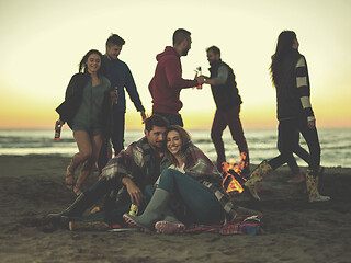 Image showing Couple enjoying with friends at sunset on the beach