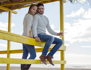 Image showing young couple drinking beer together at the beach