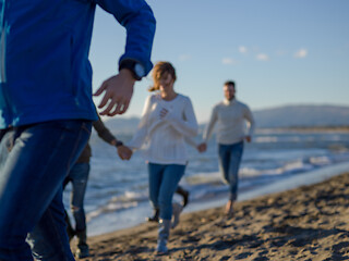 Image showing Group of friends running on beach during autumn day