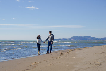 Image showing Loving young couple on a beach at autumn sunny day