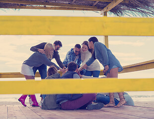 Image showing Group of friends having fun on autumn day at beach