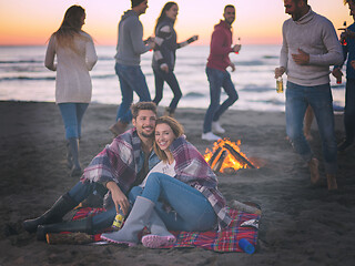 Image showing Couple enjoying with friends at sunset on the beach