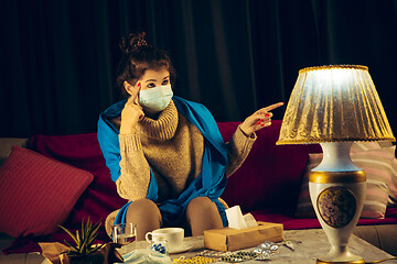 Image showing Woman wrapped in a plaid wearing face mask trying to protect from somebody\'s sick