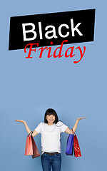 Image showing Beautiful woman inviting for shopping in black friday, sales concept. Vertical flyer, blue background