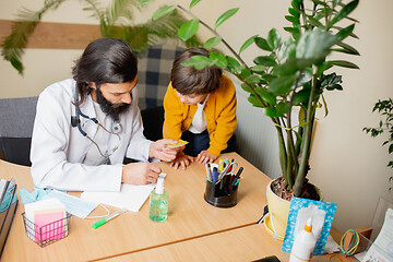 Image showing Paediatrician doctor examining a child in comfortabe medical office