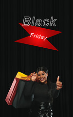 Image showing Beautiful woman inviting for shopping in black friday, sales concept. Vertical flyer, dark background