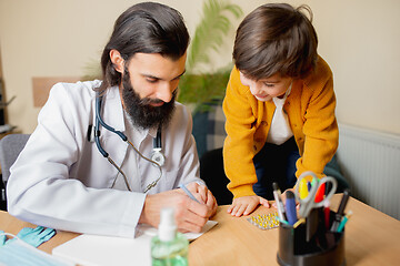 Image showing Paediatrician doctor examining a child in comfortabe medical office