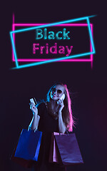 Image showing Beautiful woman inviting for shopping in black friday, sales concept. Vertical flyer, neoned style, dark background