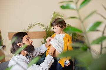 Image showing Paediatrician doctor examining a child in comfortabe medical office