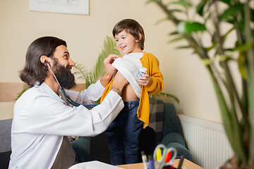 Image showing Paediatrician doctor examining a child in comfortabe medical office