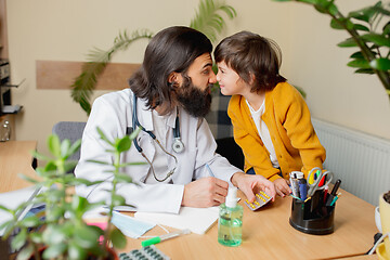 Image showing Paediatrician doctor examining a child in comfortabe medical office