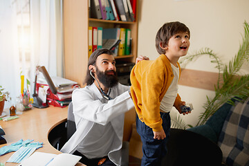 Image showing Paediatrician doctor examining a child in comfortabe medical office