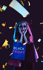 Image showing Beautiful woman inviting for shopping in black friday, sales concept. Vertical flyer, neoned style, dark background