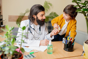 Image showing Paediatrician doctor examining a child in comfortabe medical office
