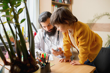 Image showing Paediatrician doctor examining a child in comfortabe medical office