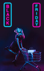 Image showing Beautiful woman inviting for shopping in black friday, sales concept. Vertical flyer, neoned style, dark background