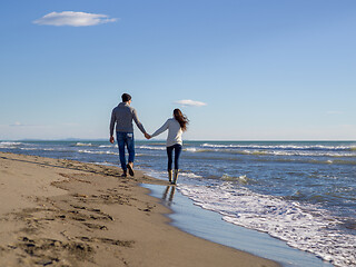 Image showing Loving young couple on a beach at autumn sunny day