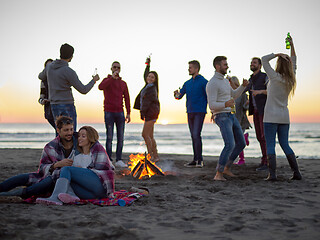 Image showing Couple enjoying with friends at sunset on the beach