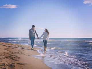 Image showing Loving young couple on a beach at autumn sunny day