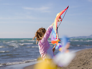 Image showing Young Woman holding kite at beach on autumn day