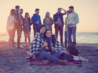 Image showing Couple enjoying with friends at sunset on the beach