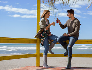 Image showing young couple drinking beer together at the beach