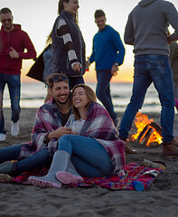 Image showing Couple enjoying with friends at sunset on the beach