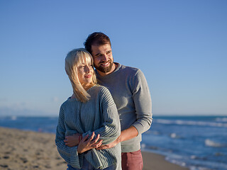 Image showing Loving young couple on a beach at autumn sunny day