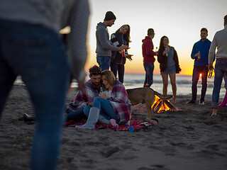 Image showing Couple enjoying with friends at sunset on the beach