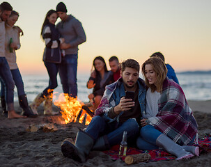 Image showing Couple enjoying bonfire with friends on beach