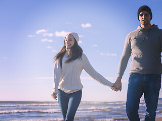 Image showing Loving young couple on a beach at autumn sunny day