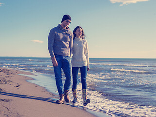 Image showing Loving young couple on a beach at autumn sunny day