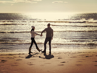 Image showing Loving young couple on a beach at autumn sunny day