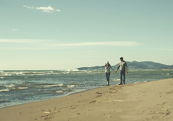 Image showing Loving young couple on a beach at autumn sunny day