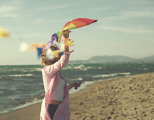 Image showing Young Woman holding kite at beach on autumn day
