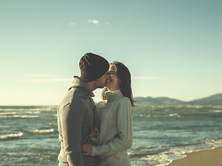 Image showing Loving young couple on a beach at autumn sunny day