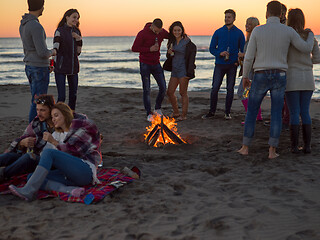 Image showing Couple enjoying with friends at sunset on the beach