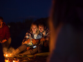 Image showing Couple enjoying with friends at night on the beach