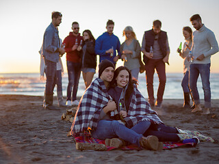 Image showing Couple enjoying with friends at sunset on the beach