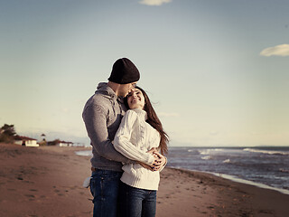 Image showing Loving young couple on a beach at autumn sunny day