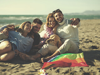 Image showing Group of friends having fun on beach during autumn day